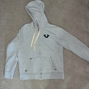 Light grey, zip up sweater.